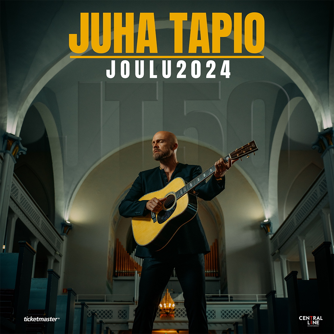 Tummapukuinen mies ja kitara tummasävyisessä kirkkotilassa. Teksti Juha Tapio joulu 2024
