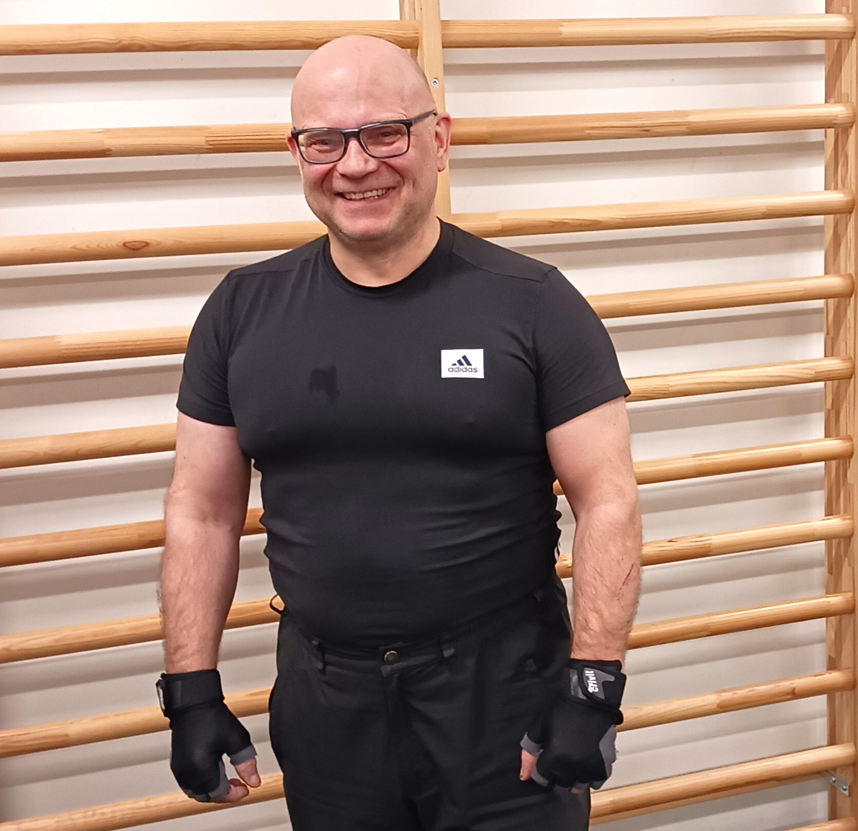 Hymyilevä mies puolapuiden edessä