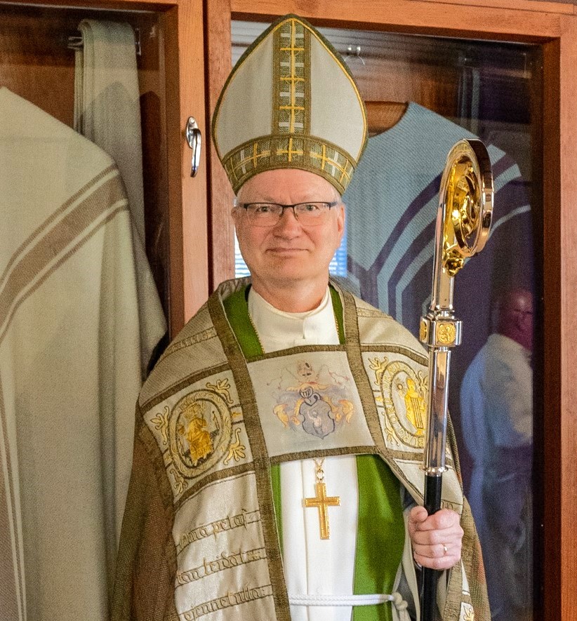 Piispa hiipassaan, sauvassaan ja ristissään.