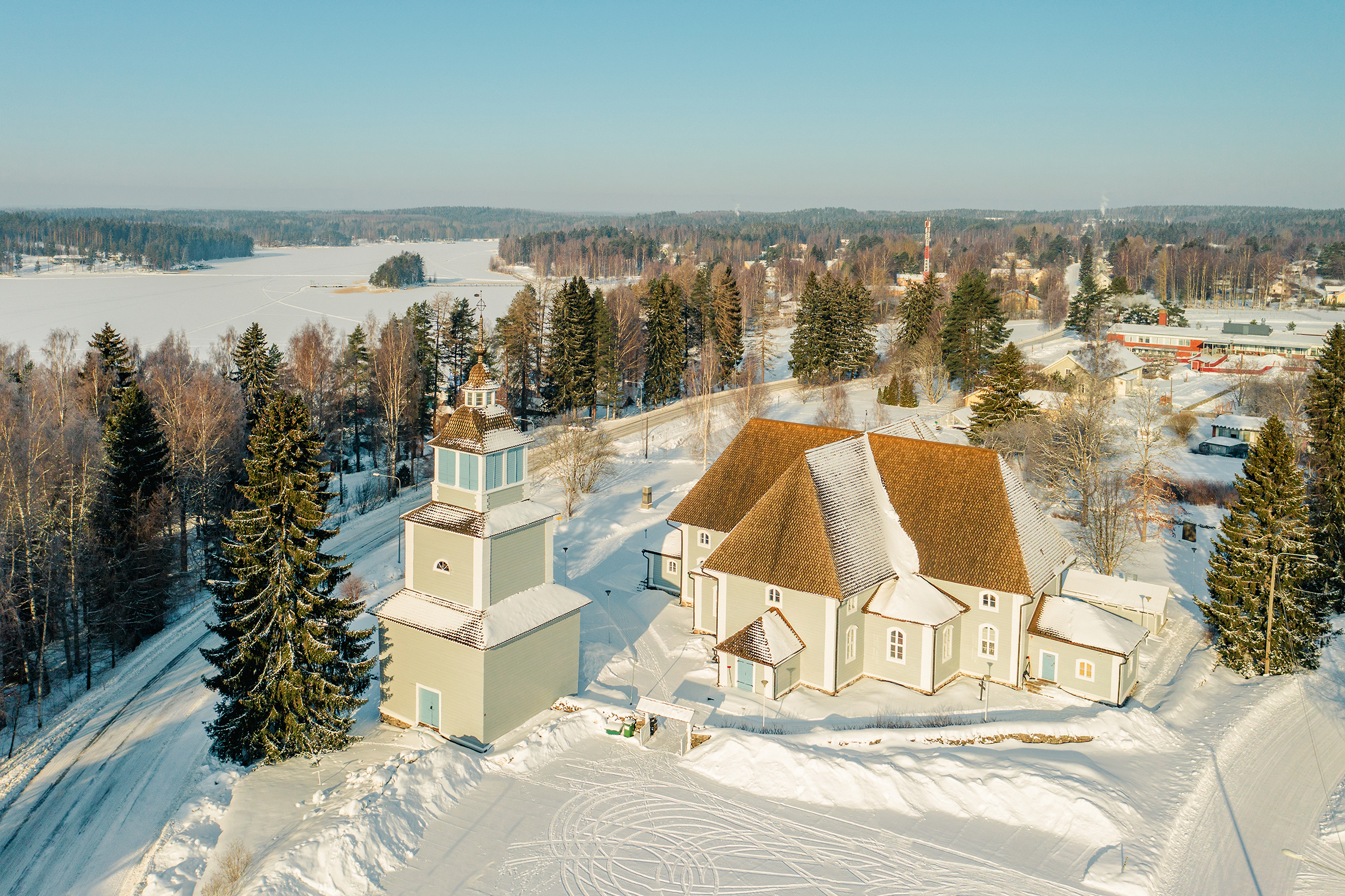 Ilmakuva Ristiinan kirkosta ja kellotapulista. Luminen maisema.