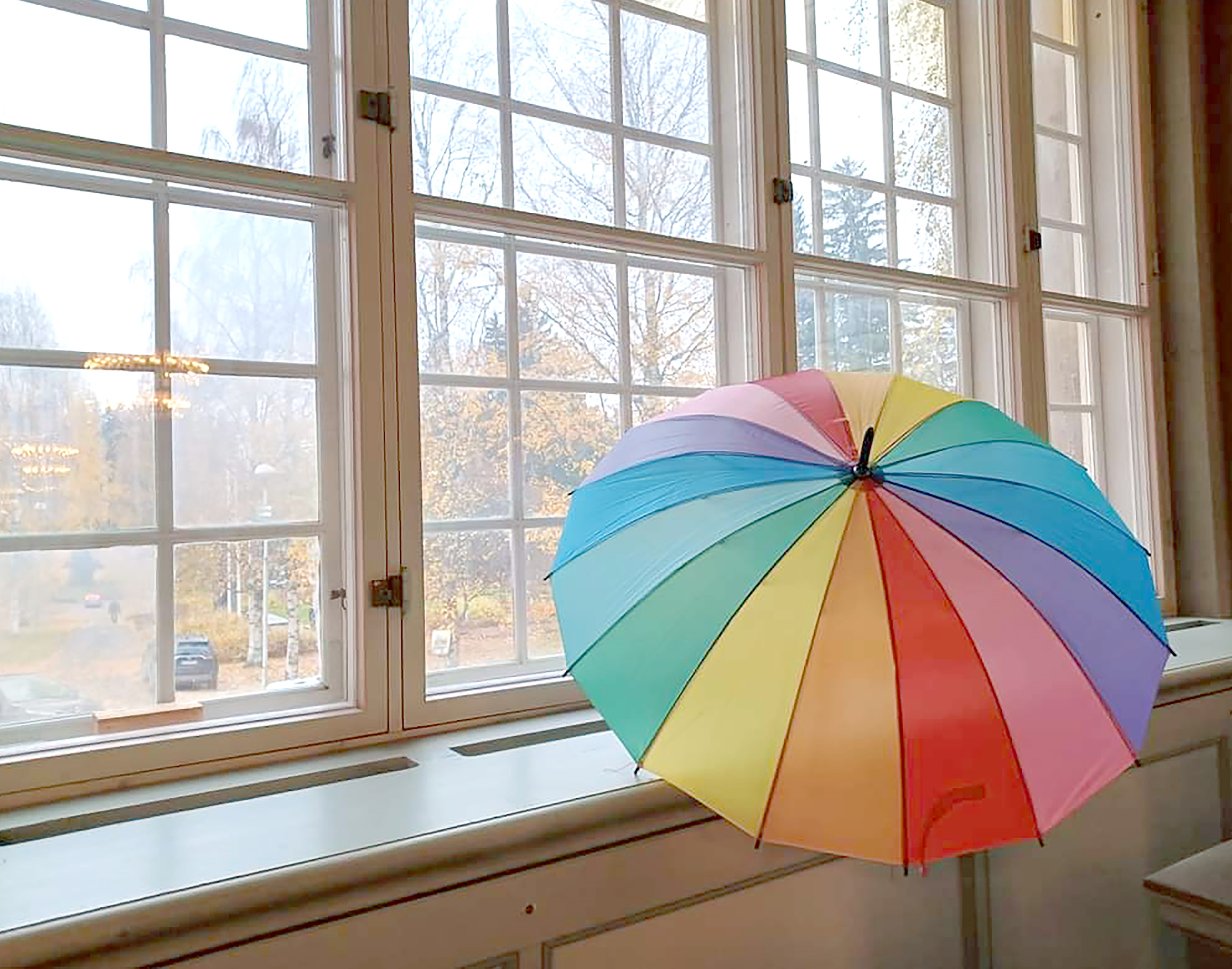 Värikäs sateenvarjo nojaa Pitäjänkirkon ikkunaan