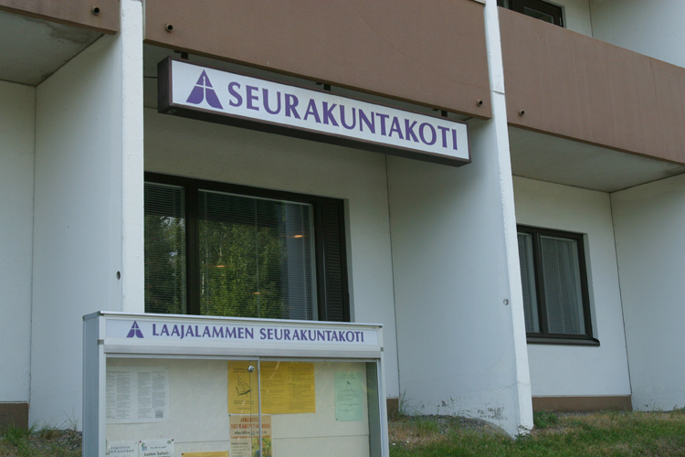 Laajalammen seurakuntakodin ikkuna Kaituentieltä päin. Edessä ilmoitustaulu.