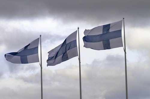kolme Suomen lippua lipputangoissa liehumassa