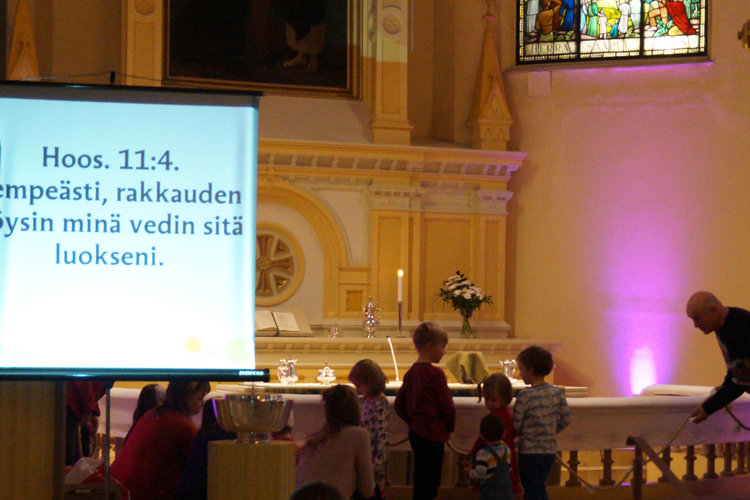 Lapset ja aikuisia tuomiokirkon alttarin edessä viettämässä messimessua.