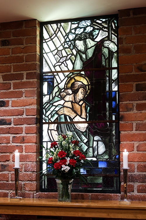 Kryptan lasimaalaus esittää Jeesuksen kastetta. Lasimaalauksen on tehnyt Bruno Tuukkanen.